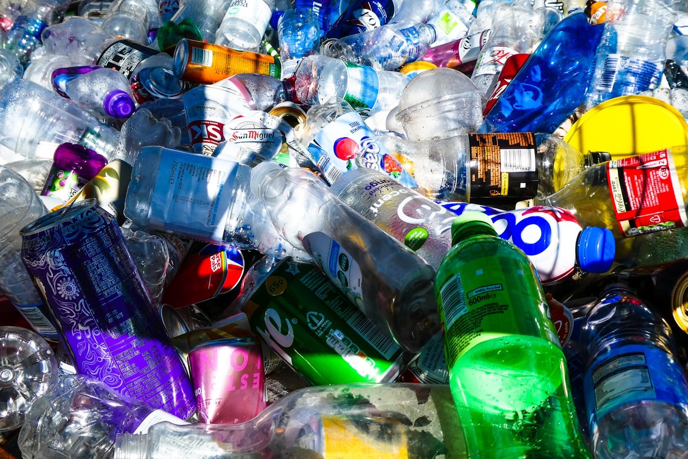 Pile of single-use plastic bottles — the problem Greenora solves